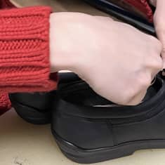 Kenkä ja naisen kädet