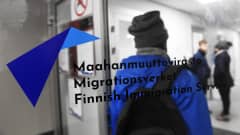 En person stiger in genom dörren till Migrationsverket