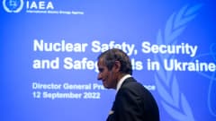 IAEA:n pääsihteeri Rafael Grossi kävelee kokouksessa. Taustalla sininen seinä, jossa valkoista tekstiä.
