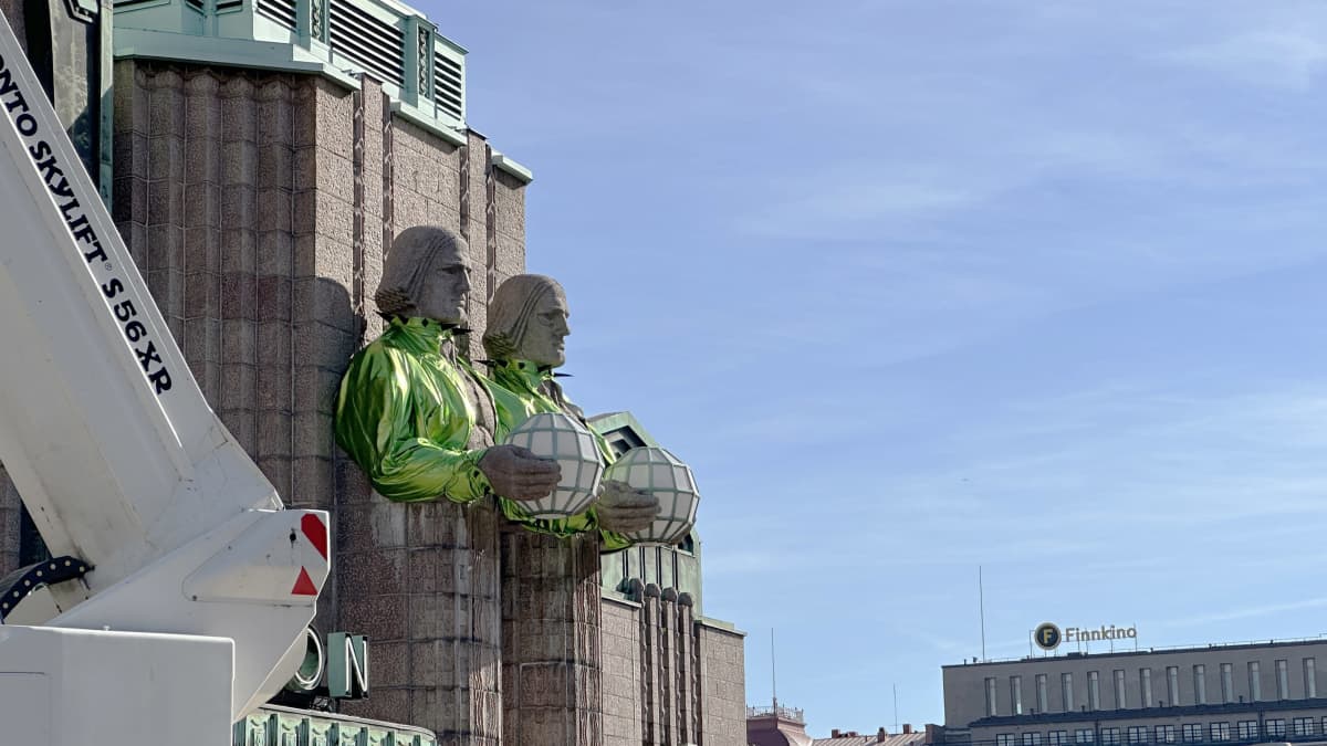 Kivimies-patsaat on puettu kirkkaanvihreisiin boleroihin.