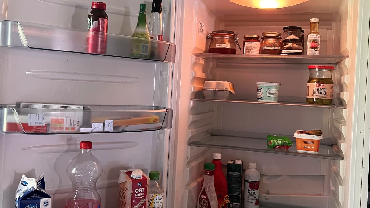Jääkaapin sisältö kuvattuna. Jääkaapissa on muun muassa hillopurkkeja, maito, ketsuppi ja maustekurkkuja.