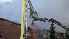 Firefighters on cranes combat a blaze on the roof of a school in Espoo.