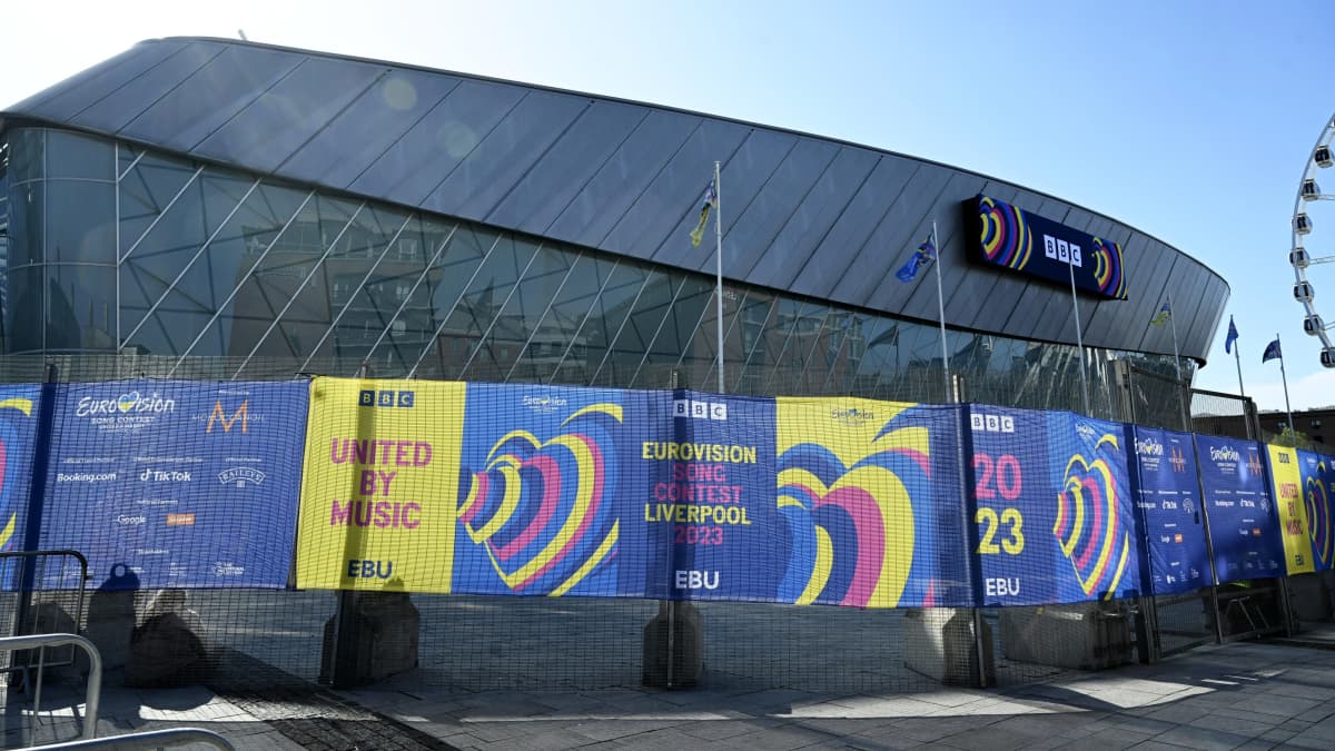 Euroviisujen näyttämö Liverpool Arena värikkäiden mainosaitojen takana aurinkoisessa säässä.