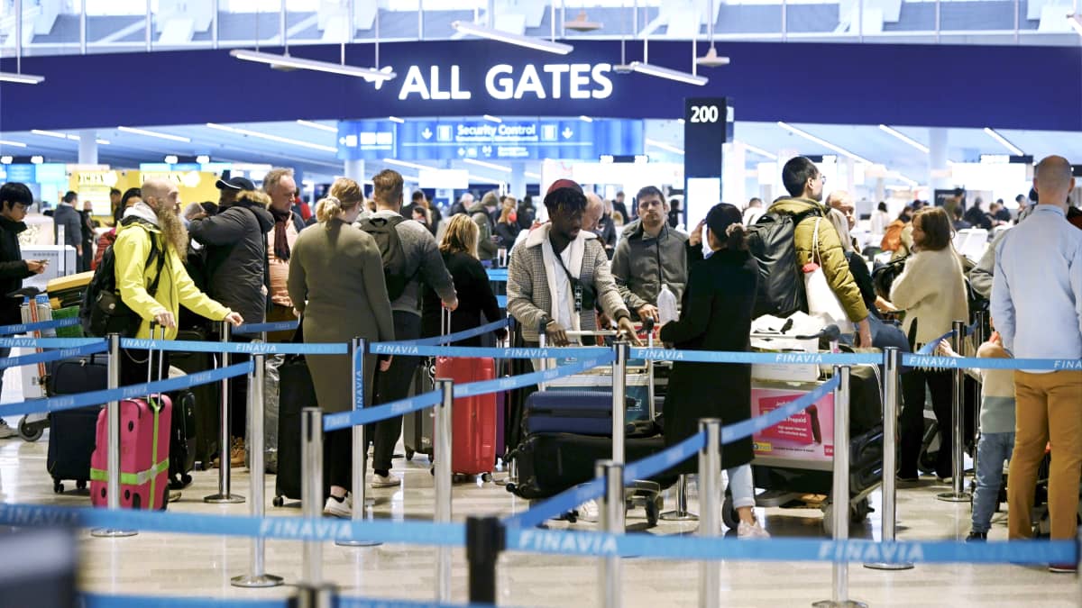 Matkustajat jonottavat turvatarkastukseen lentoasemalla.