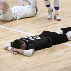 Futsalpelaajat makaavat maassa.
