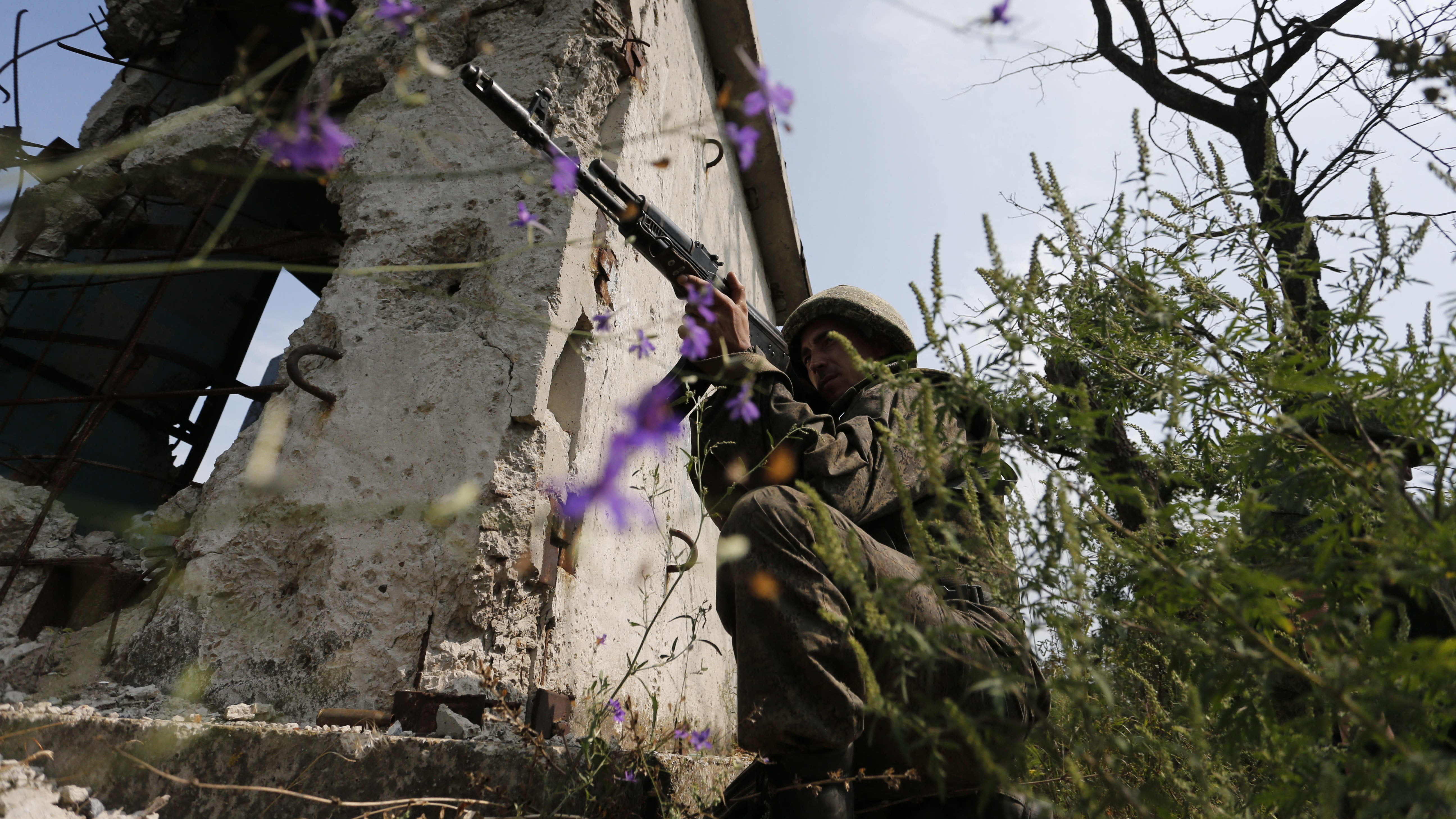 Venäläismielinen separatisti sotilas tähtää aseella.