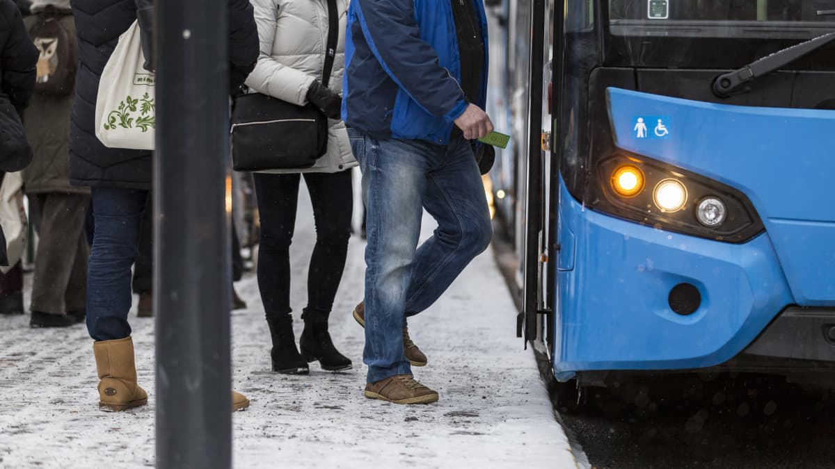 Ihmisiä nousemassa bussin kyytiin Helsingissä.