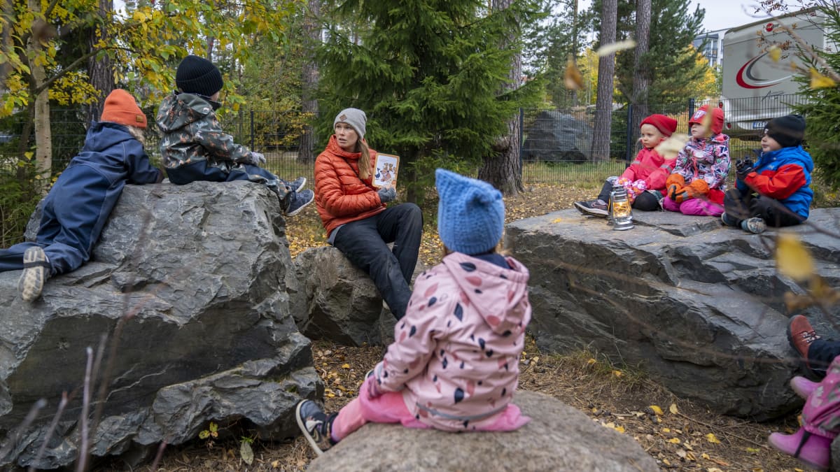 Juulia Jantunen, varhaiskasvatuksen opettaja, päiväkoti Kanavan viereisessä metsikössä leikkimässä lasten kanssa