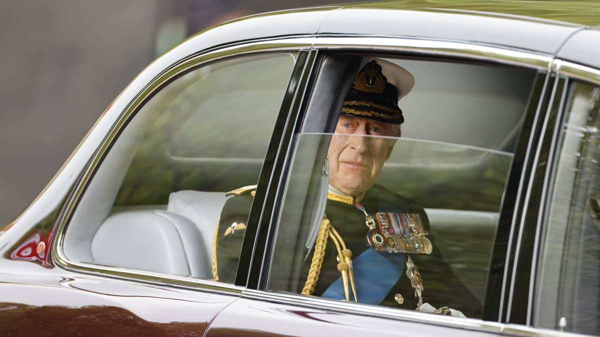 Kuningas Charles katsoo ulos auton ikkunasta.