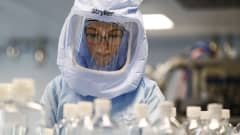 Suojapukuun pukeutunut yöntekijä testaa rokotevalmistuksen prosesseja Biontechin tehtaalla Saksan Marburgissa