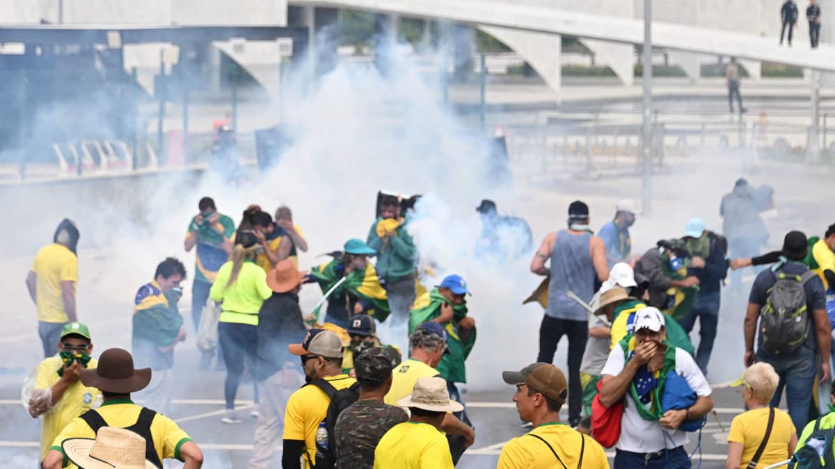 Demonstranter och rökgas i Brasiliens huvudstad Brasília utanför regeringsbyggnaden Palácio do Planalto.