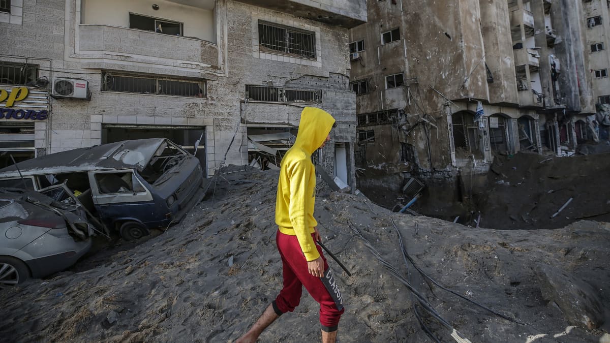 Poika kävelee öisten ilmaiskujen tuhojen ohitse Gazan kaupungissa keskiviikkona.