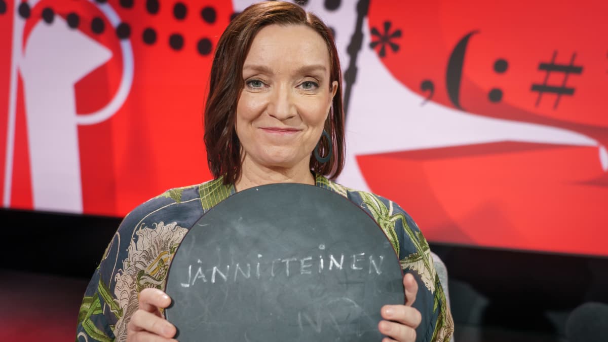  MTV:n politikka- ja yhteiskuntaosaston päällikkö Eeva Lehtimäki henkilökuvassa Viimeinen sana-ohjelman lavasteissa. Hänellä on käsissään pyöreä liitutaulu, jossa lukee "jännitteinen"."