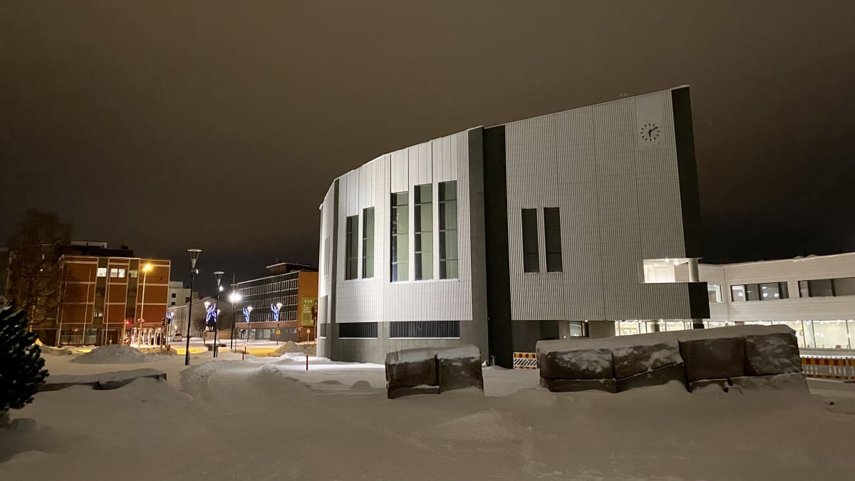 Rovaniemen kaupungintalo hämärässä illassa. Maassa on lunta. 