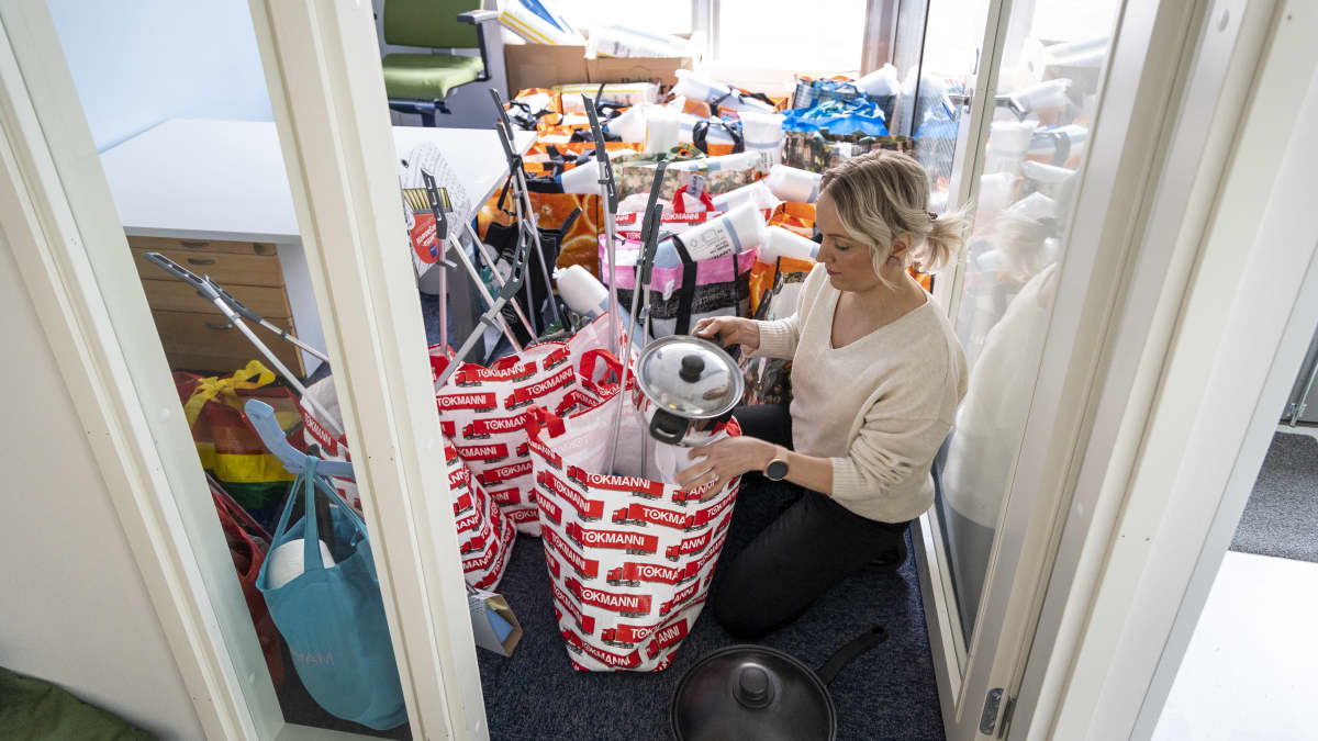 Sairaanhoitaja Kirsi Soinen tarkastelee tarvike kasseja jossa hyödyllisiä tavaroita pakolaisille elämiseen.