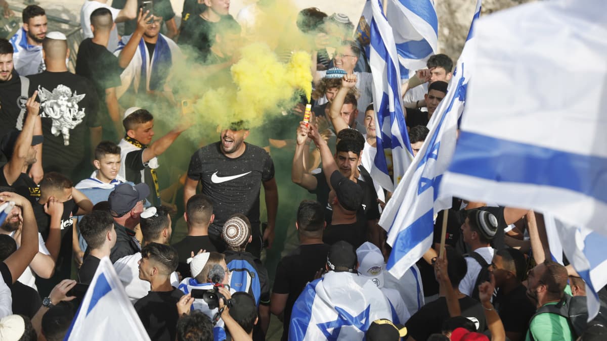 Ihmiset kannattelevat Israelin lippuja ja joku on sytyttänyt keltaista huomiosavua ilmoille syöksevän soihdun.