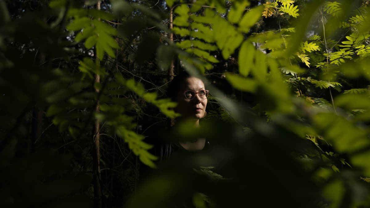 Riikka Kaihovaraa henkilökuvassa metsässä.