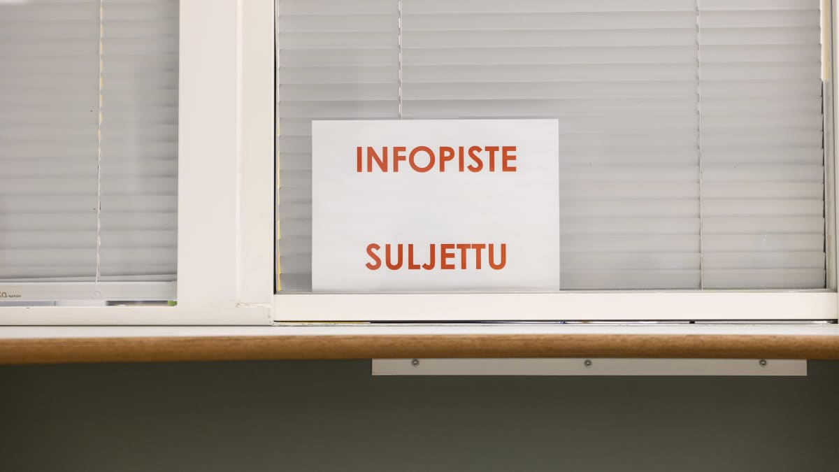 Asiakaspalvelupisteen suljettuun ikkunaan kiinnitetty lappu: infopiste suljettu.