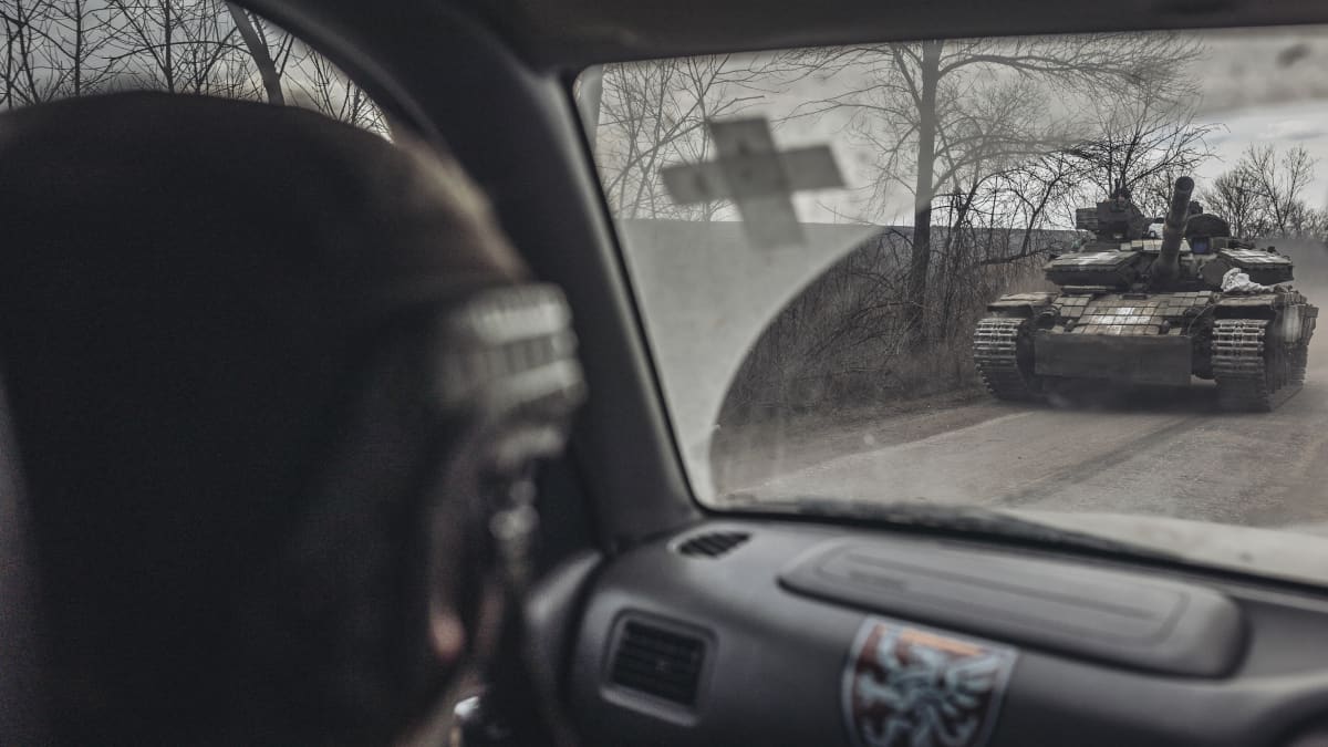 80. prikaatin ukrainalainen sotilas katsoo tiellä kulkevaa panssarivaunua Bahmutin alueella Itä-Ukrainassa.
