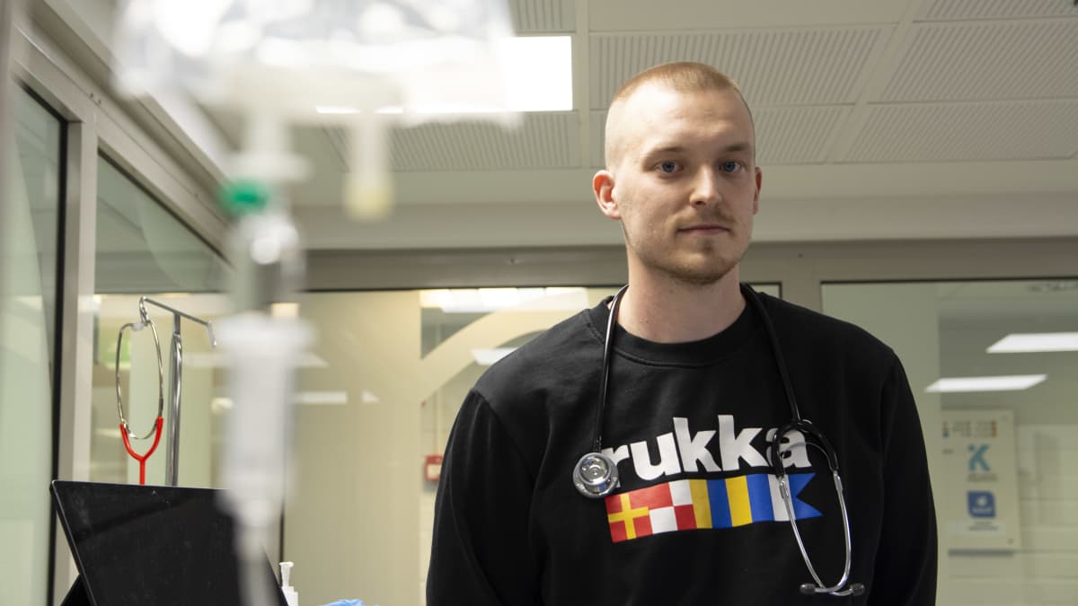Sairaanhoitajaopiskelija Mikko Huovisen kaulassa roikkuu stetoskooppi, ja hän katsoo suoraan kameraan.