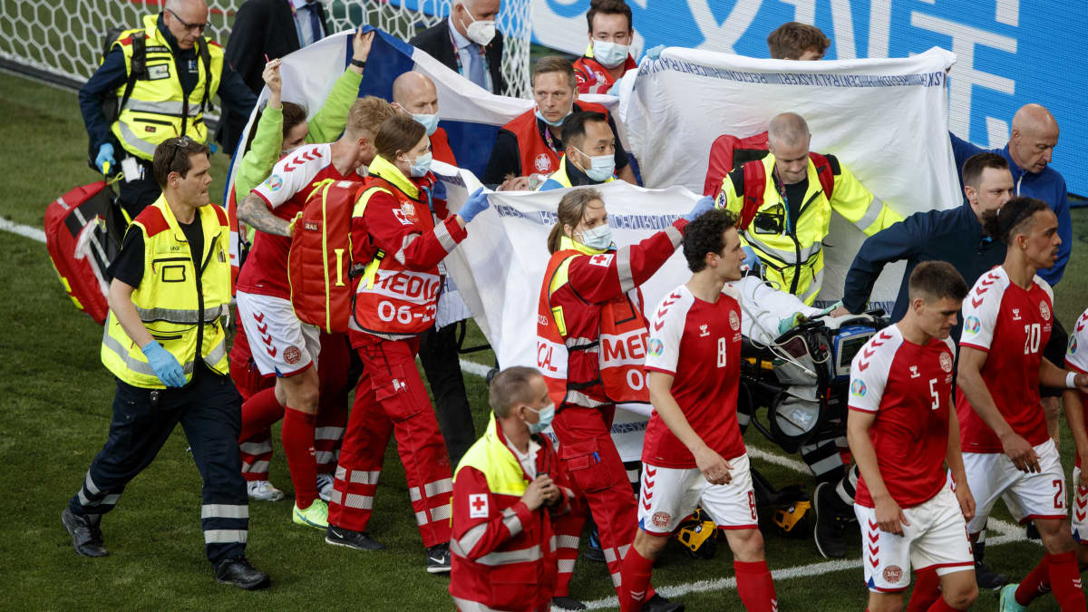 Tanskan Kööpenhaminan Parkenin hoitohenkilökunta viemässä Christian Erikseniä pois.