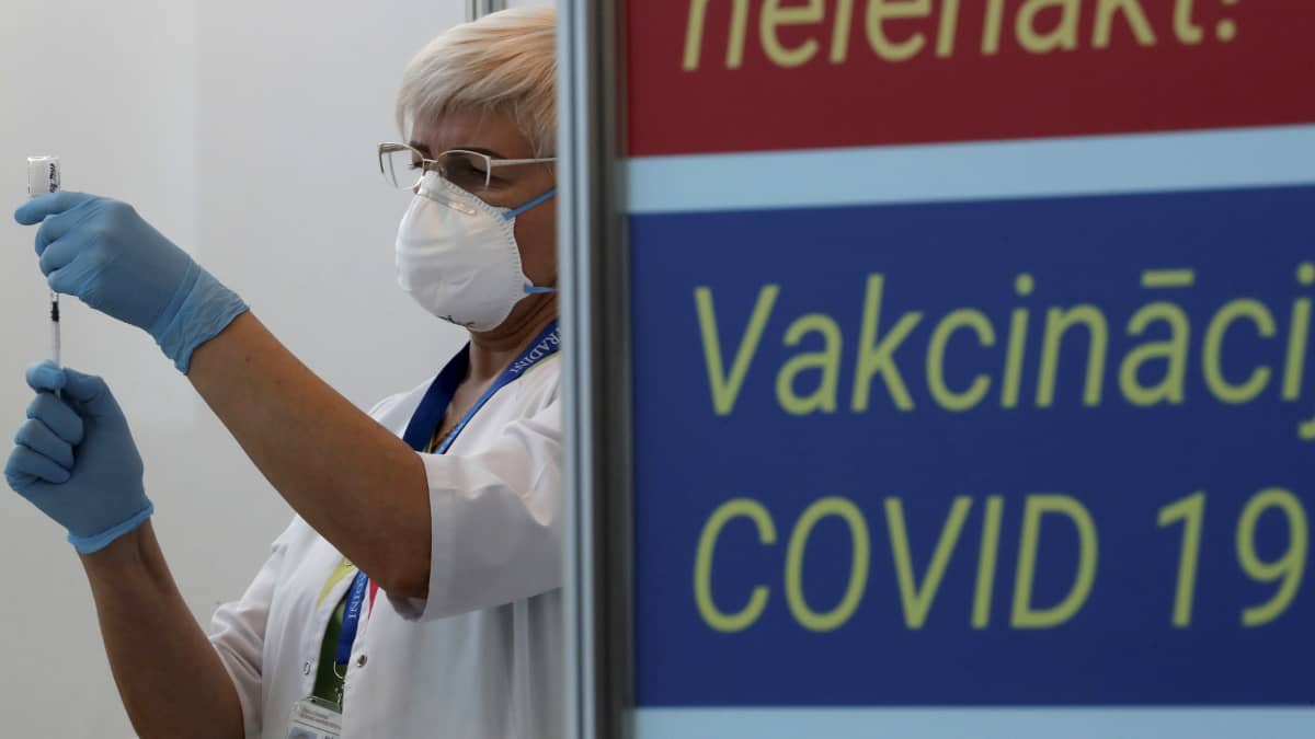 Riikalaisen sairaalan työntekijä valmistelee rokoteannosta.