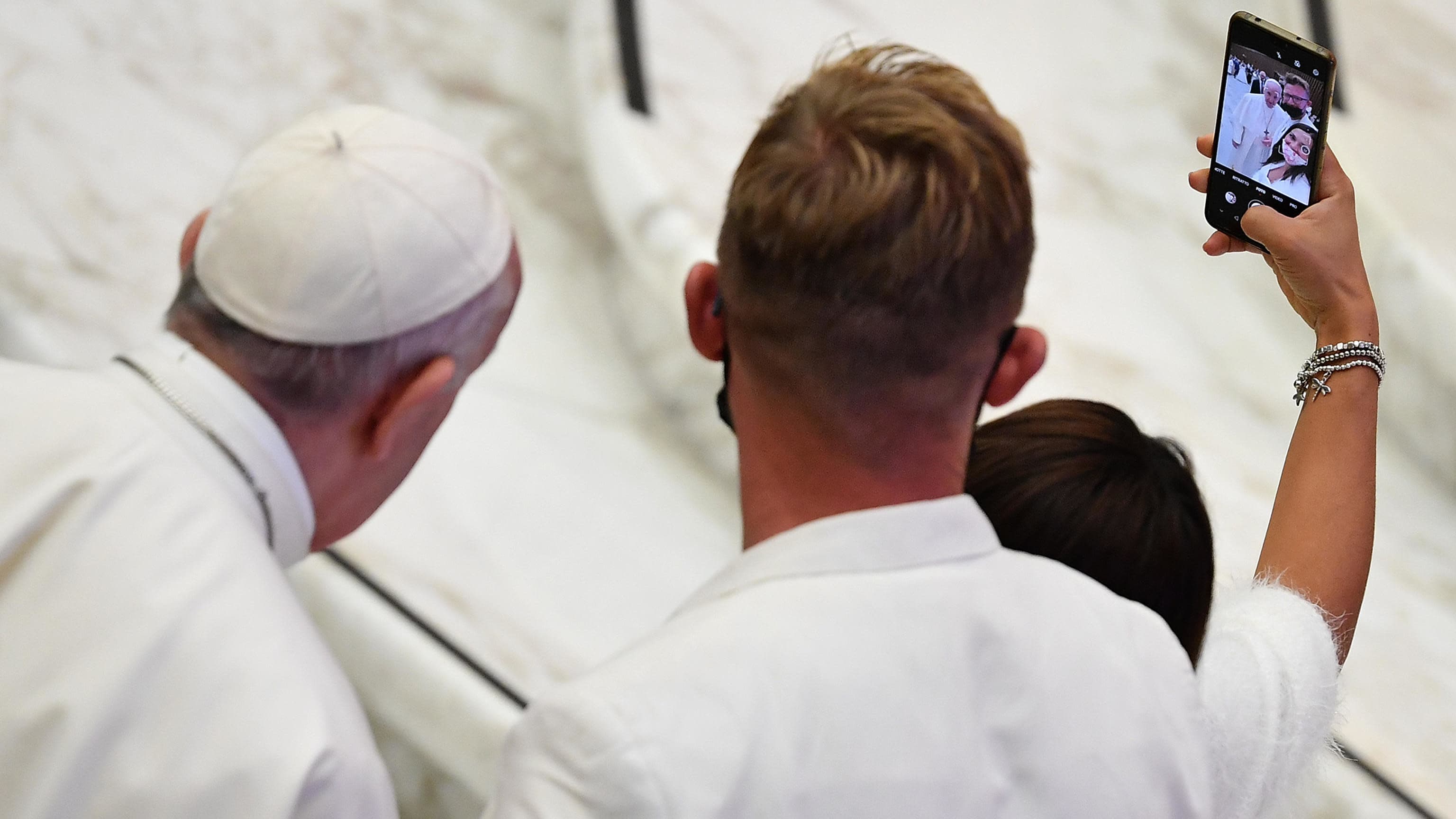 Pariskunta ottaa paavin kanssa selfien.