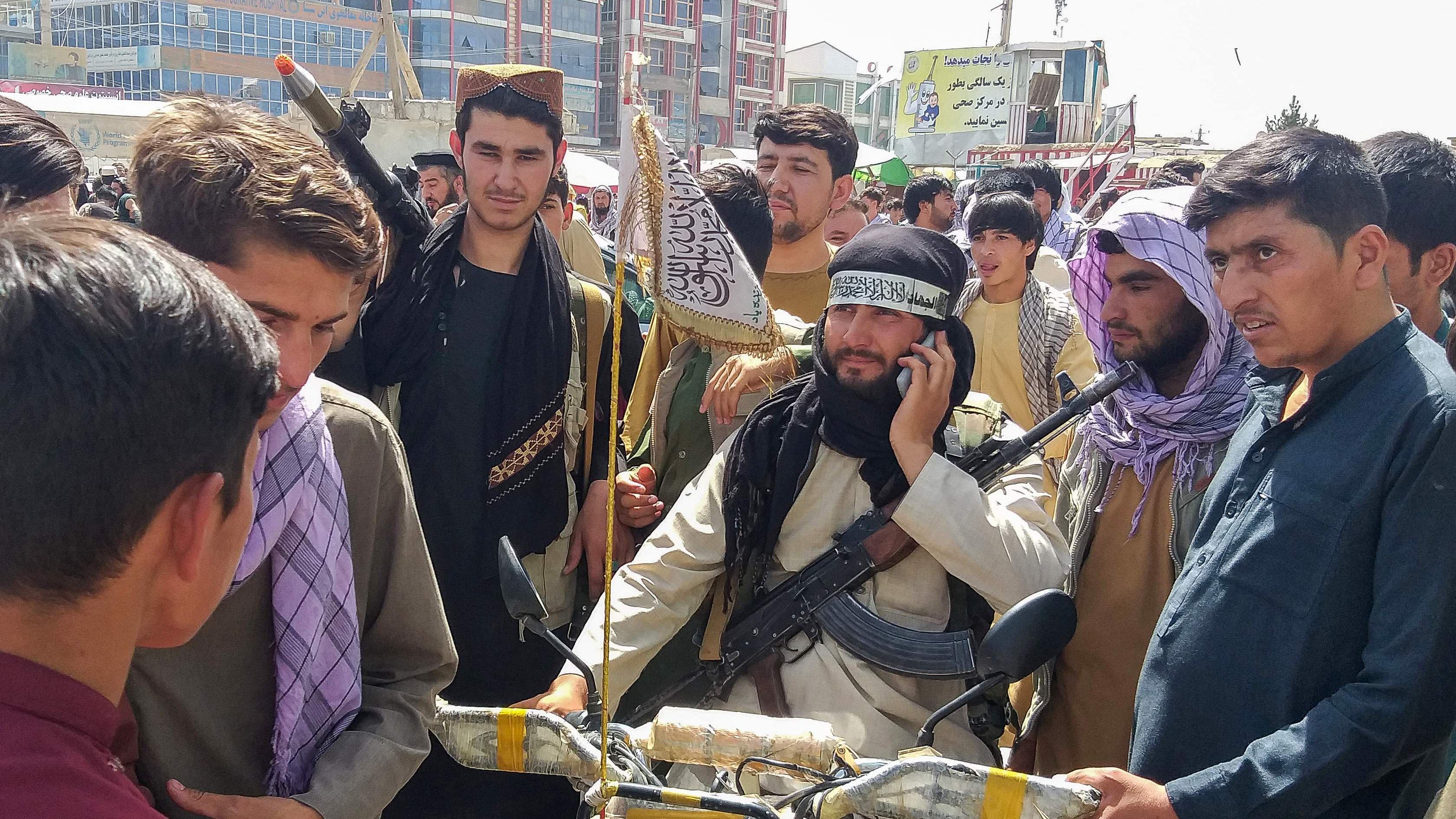 Taleban-taistelija paikallisten ympäröimänä Pul-e-Khumrissa.
