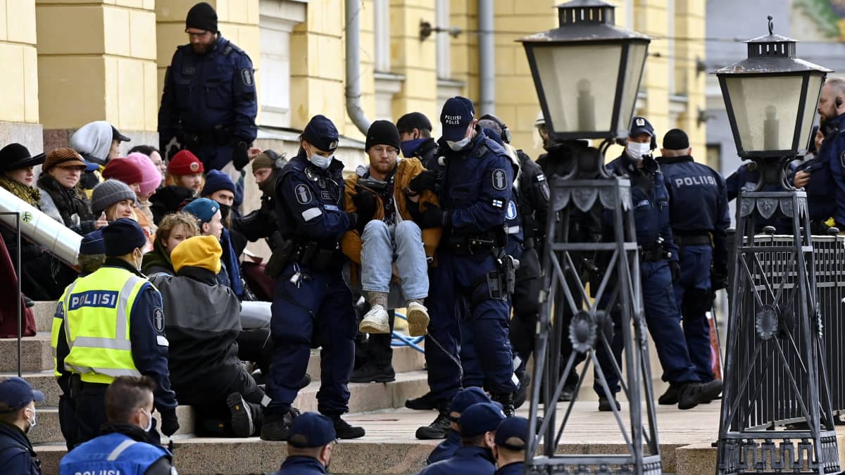 Poliisi siirtää mielenosoittajia pois paikalta - Ympäristöliike Elokapina lukittautui Valtioneuvoston linnan edustalle Helsingissä 8. lokakuuta 2021.