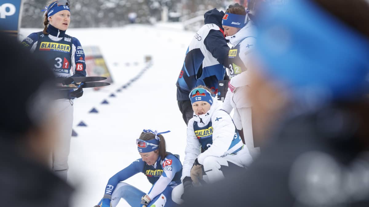 Suomen joukkue naisten viestin jälkeen. Krista Pärmäkoski istuu pettyneenä maassa.