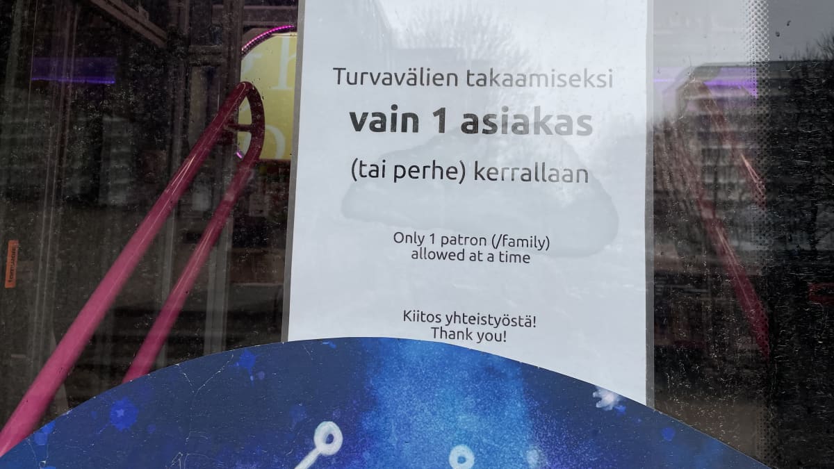 Kirjastoauton ovessa korona-ajan rajoitushuomautus, vain yksi asiakas kerrallaan
