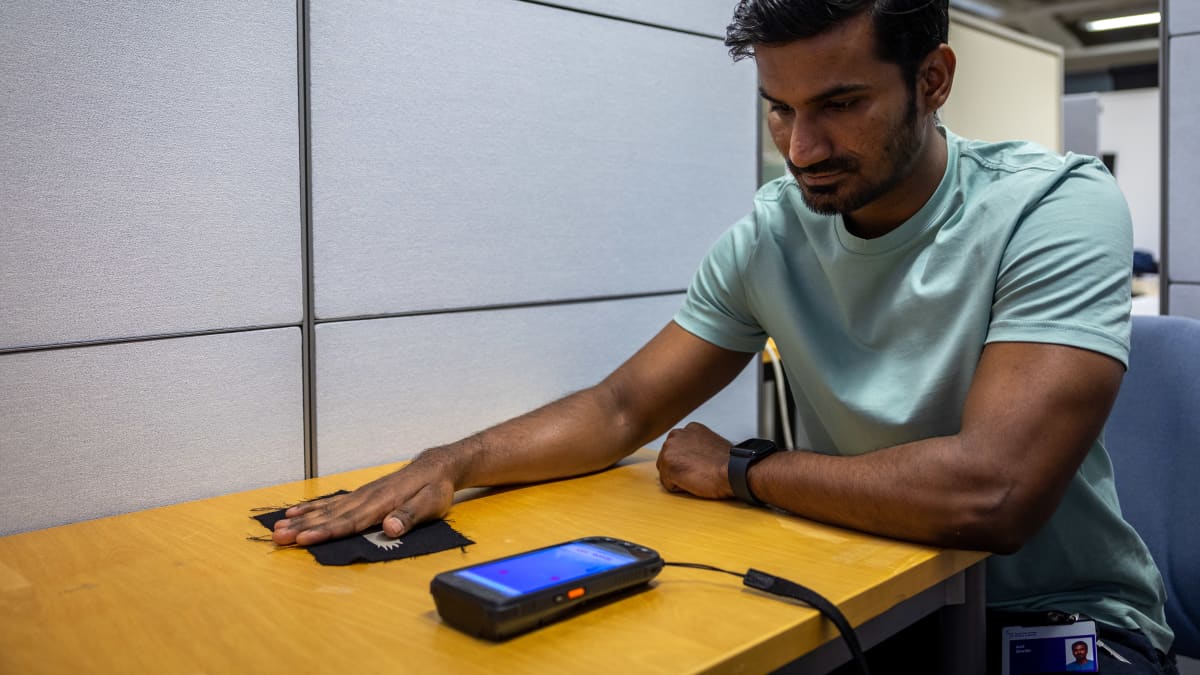 Shaikh Asif testaamassa kankaaseen kiinnitetyn lintukuvion avulla ohjattavaa mobiilipeliä.