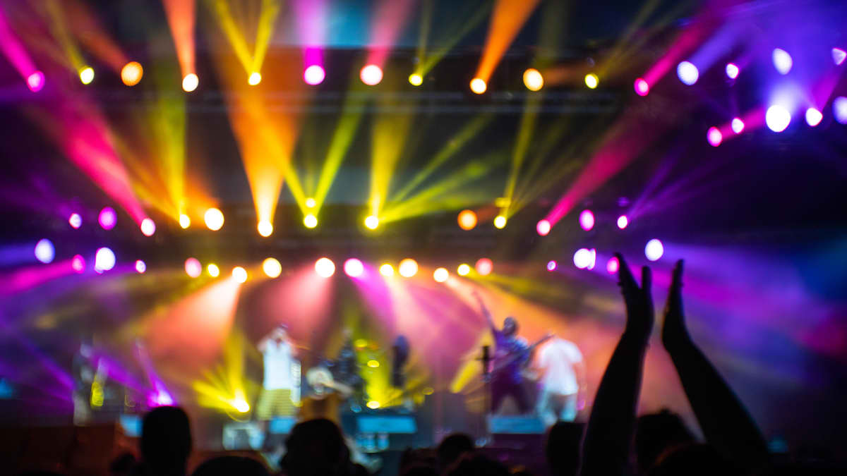 En människa viftar med händerna under en konsert.