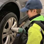 13-vuotias Aati Junttila vaihtaa autoon talvirenkaita Seinäjoella tallissa.