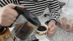 nainen kaataa kahvia