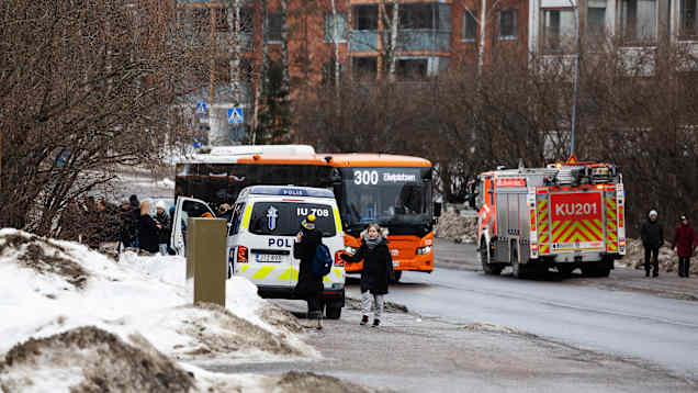 Media ja ohikulkijat seurasivat tilannetta talon edustalla.