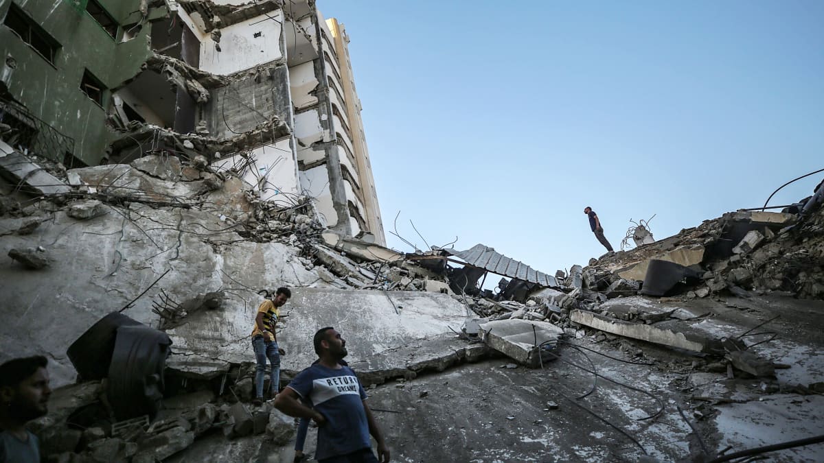 Palestiinalaiset tarkastelevat tuhoutuneen rakennuksen raunioita..