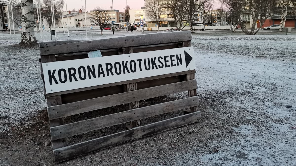 Kuormalavaan kiinnitetty Koronarokotukseen ohjaava kyltti Rovaniemen pääkirjaston edessä