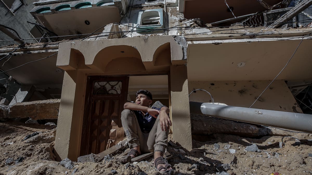 Palestiinalaispoika istuu Israelin pommittaman talon raunioilla Gazassa 13.5.2021.