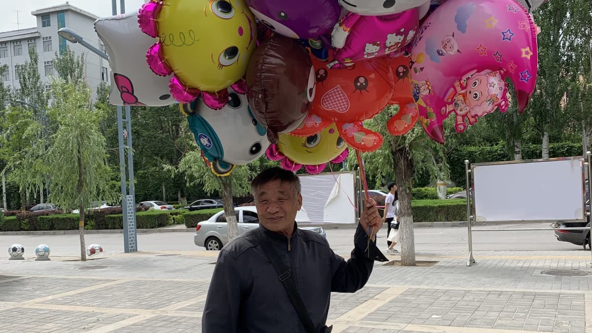 Gao Xinliang kimppu ilmapalloja kädessään