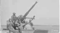 En svartvit bild av fem soldater som manövrerar en luftvärnskanon på fartyget Ilmarinen vid Bengtskär under fortsättningskriget.