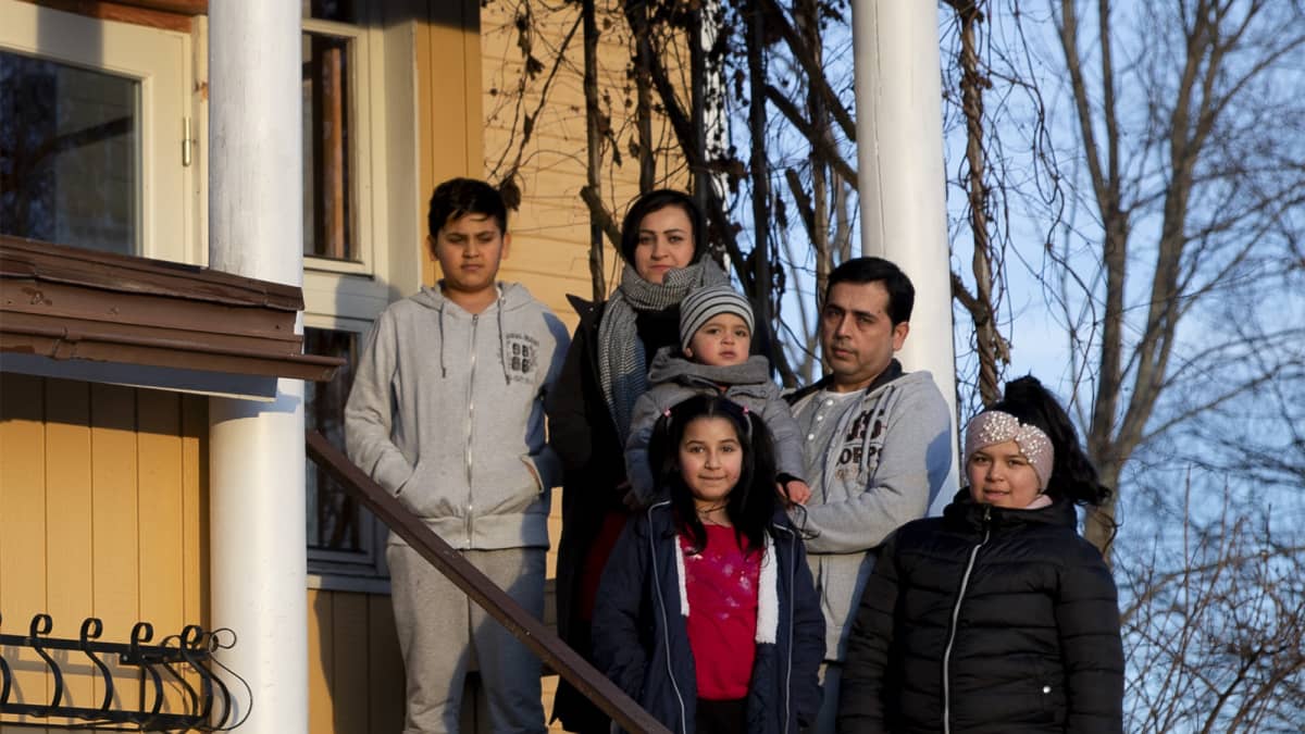 Afganistanilainen, turvapaikan saanut Azimin perhe kotitalonsa portailla Kyyjärvellä.