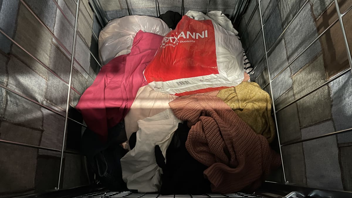 Poistotekstiilien keräysrullakkoon on jätetty kierrätykseen meneviä vaatteita.