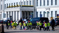 Lapsia keltaiset turvaliivit päällään kävelee Helsingin kauppatorilla.