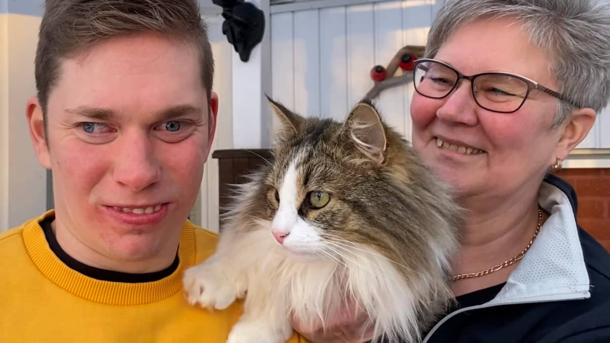 Paula Portin ja Aleksi Portin seskä kissa heidän välissään lähikuvassa.