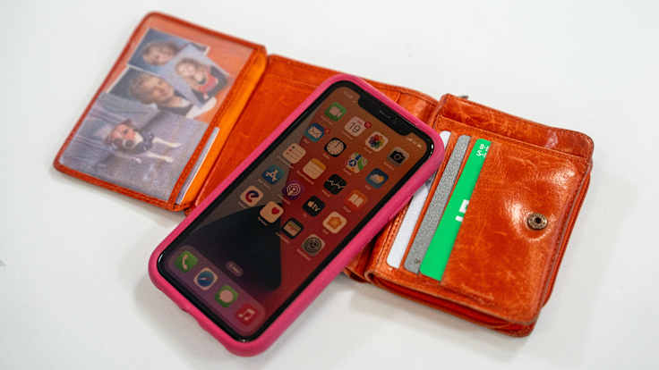 Kännykkä ja avoin lompakko pöydällä.