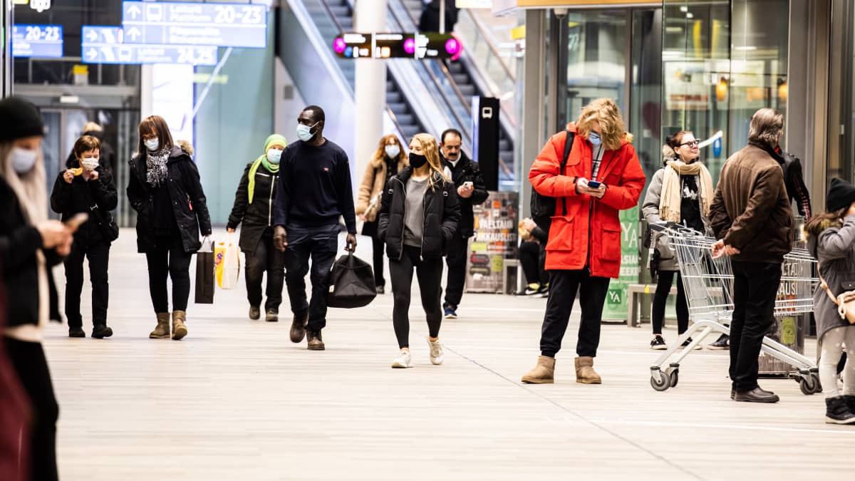 Ihmisiä odottaa bussia Matinkylän metroaseman bussiterminaalissa 25.maaliskuuta 2021.
