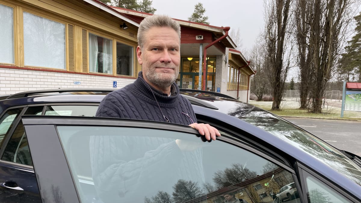 Ajo-opettaja Juha-Pekka Leiponen seisoo opetusauton edessä. Takana näkyy Ähtärin lukion rakennus.