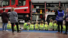 Lapset kuuntelemassa paloauton esittelyä.
