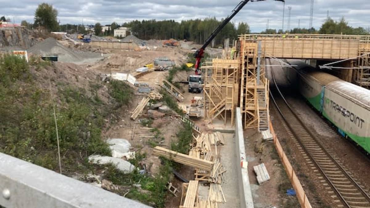 Hyväntuulentie katkaistuna. Rakennustyömaa, puisia rakennustelineitä ja junaraide. 